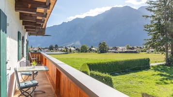 Ein Balkon mit Holzboden, einem Tisch und einem Stuhl.