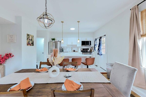 A modern kitchen with white cabinets, a central island, and pendant lighting.
