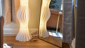 A room with a standing lamp, a mirror, and a window with curtains. - The Coffeehouse - King Bed - Gym - Fast WiFi - Full Kitchen - Great Vibes (Baltimore)