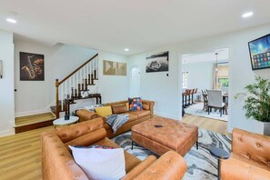 A spacious living room with a large sectional sofa, a coffee table, and a staircase leading to another level.
