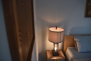 A bedside table with a lamp, a wooden headboard, and a bed with a pillow. - The Coffeehouse | King Bed·Gym·Music·Full Kitchen! (Baltimore)