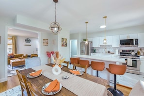 A modern kitchen with white cabinets, stainless steel appliances, and a central island.