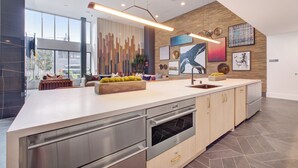 A modern kitchen with a large island, stainless steel appliances, and a wooden accent wall. - Premium 1-bedroom apartment with Gym &Work Desk (San Francisco)
