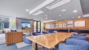 A modern conference room with a large wooden table, blue upholstered chairs, and a television on the wall. - Premium 1-bedroom apartment with Gym &Work Desk (San Francisco)