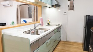 Cozinha moderna com ilha central, eletrodomésticos de aço inoxidável e uma pequena janela.