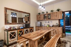 Una cocina con armarios de madera, una mesa de madera y bancos.