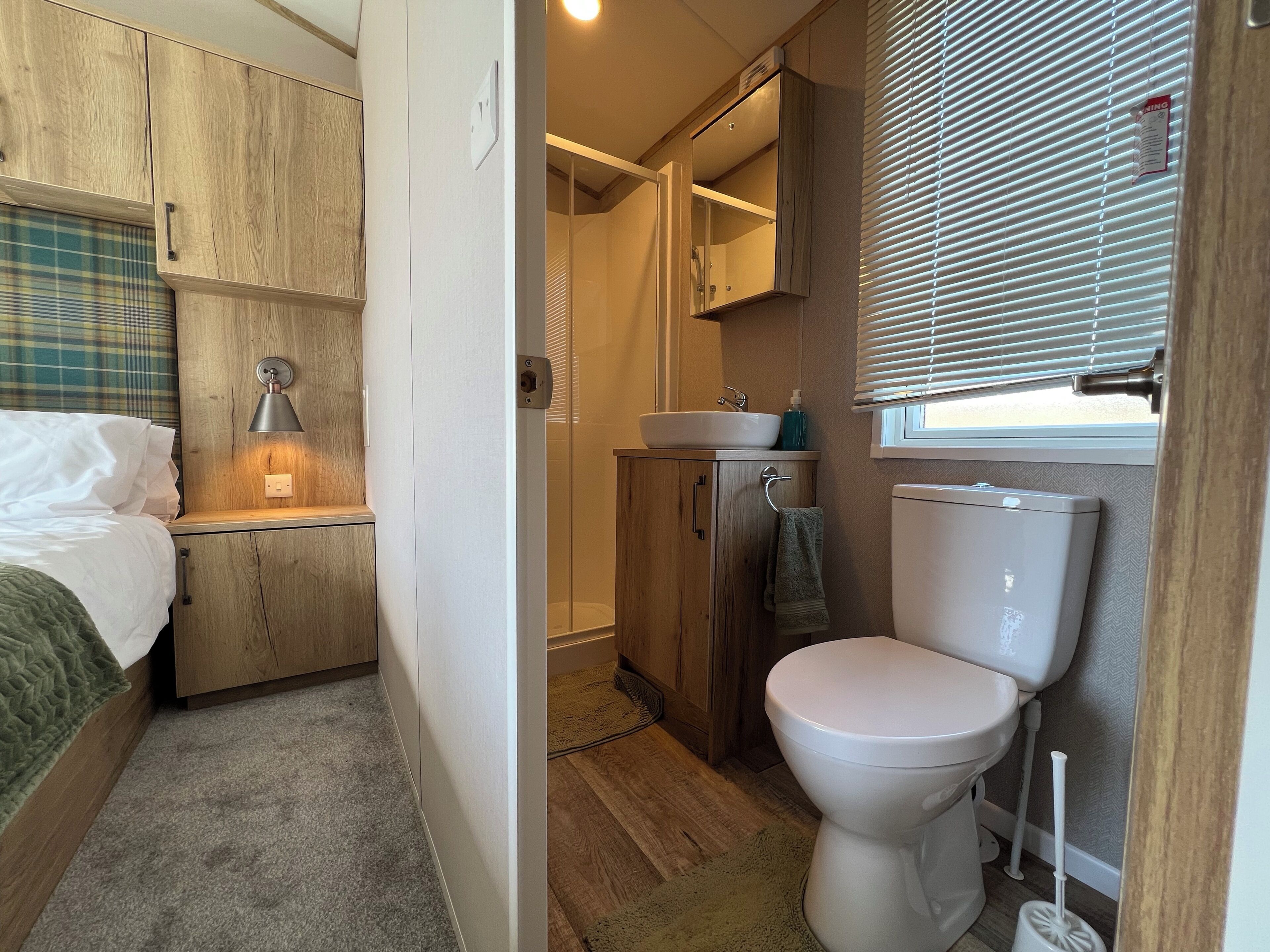 A compact bathroom with a toilet, sink, and shower.