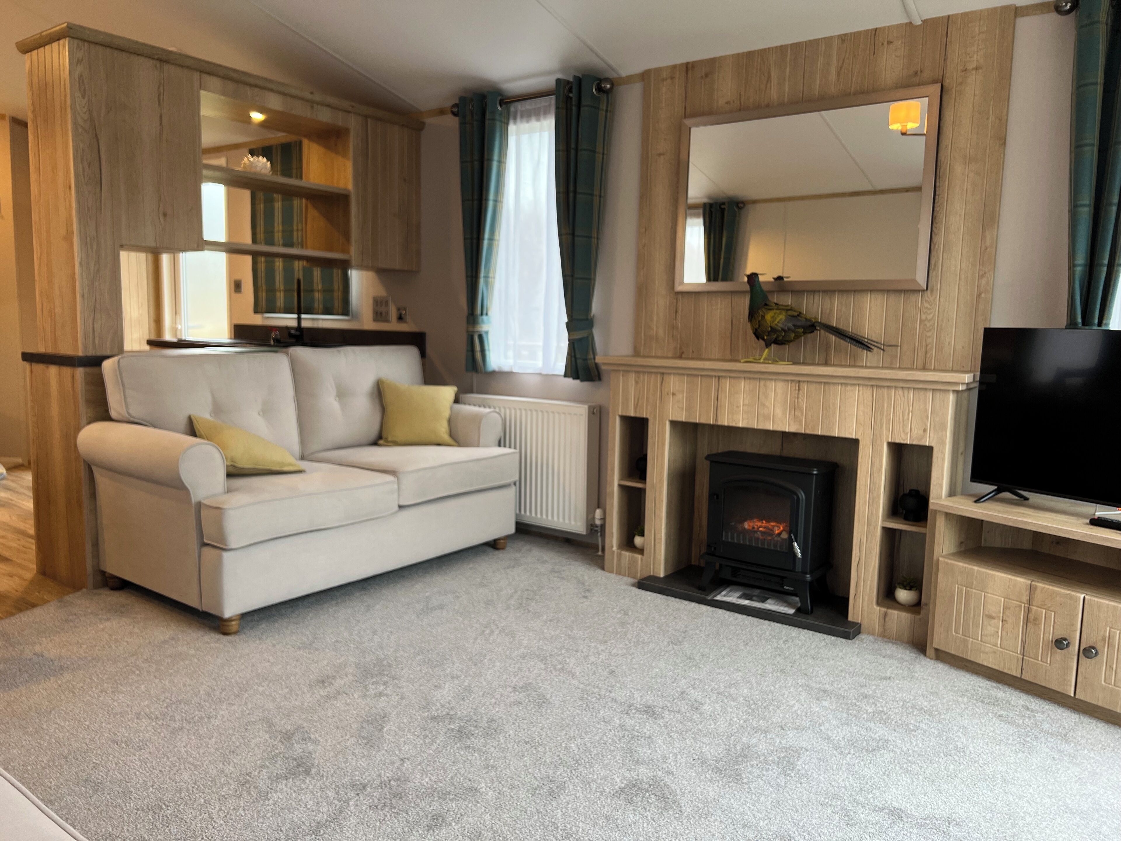 Una sala de estar con sofá, chimenea, televisor y paneles de madera.