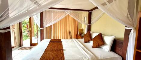 Una cama doble con dosel, cabecera de madera y un corredor decorativo marrón.