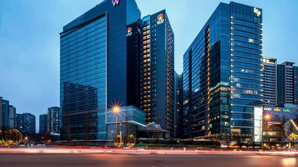 A modern cityscape with high-rise buildings, including a prominent W-shaped logo on one building. - Hengjing Yushi Hotel (Chengdu)