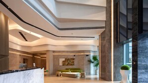 A modern lobby with a reception desk, seating area, and a large window. - Hengjing Yushi Hotel (Chengdu)