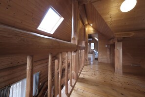 A wooden interior with a sloped ceiling, skylights, and a central wooden beam structure. - Shakunagedaira Vacation Rental Lot 2 (Inawashiro)