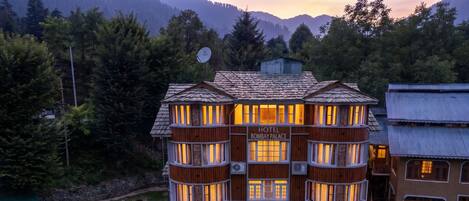 A multi-story hotel with a checkered roof, wooden exterior, and multiple balconies.