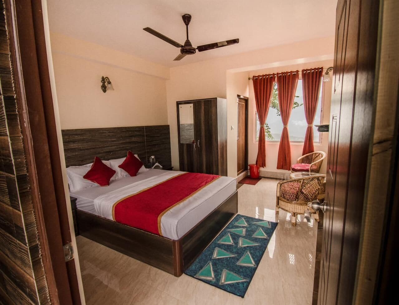 Ein Hotelzimmer mit Bett, Kleiderschrank, Deckenventilator und Blick ins Freie.