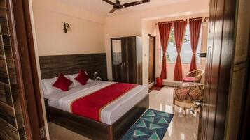 Ein Hotelzimmer mit Bett, Kleiderschrank, Deckenventilator und Blick ins Freie.