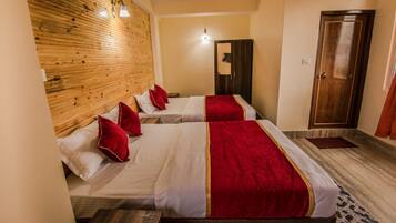 A hotel room with two beds, wooden headboard, a ceiling fan, and a wardrobe.