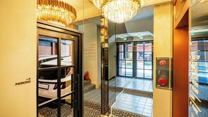 Eine Hotelhalle mit Parkschild, Rezeption und einer Chandelüstere.