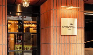 A hotel entrance with a sign reading 'Urbanflow hotel' and a modern interior visible through the glass doors. - Sinchon Urbanslow (Seoul)