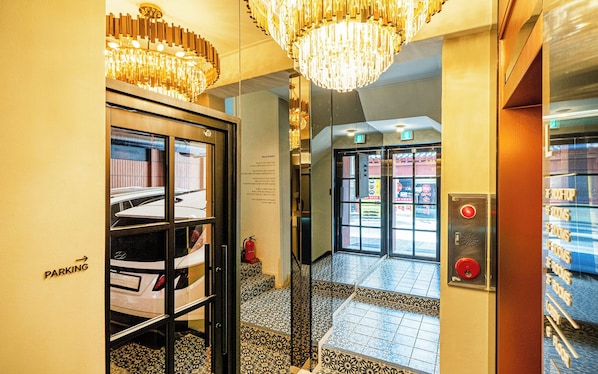 A hotel lobby with a parking area, a reception desk, and a staircase leading to the upper floors. - Sinchon Urbanslow (Seoul)