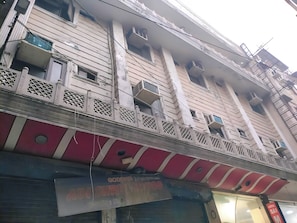 A multi-story building with balconies, a red awning, and a sign with partially visible text. - Sai Mahal Hotel Near New Delhi Railway  (New Delhi)