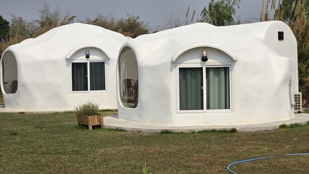 Two dome-shaped structures with arched windows and a small door, surrounded by grass and plants. - FIELD GOOD Resort at Chiang Rai (Chiang Rai)