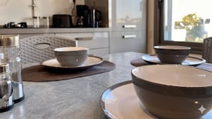 Eine moderne Küche mit Marmorfliesenspiegel, einer Kaffeemaschine und Blick auf die Stadt durch das Fenster.