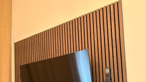 Un televisor de pantalla plana sujeto a un panel de madera a modo de revestimiento.