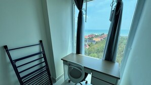 A room with a desk, chair, and a window with curtains. - Nam Talay by PSR (Nongprue)