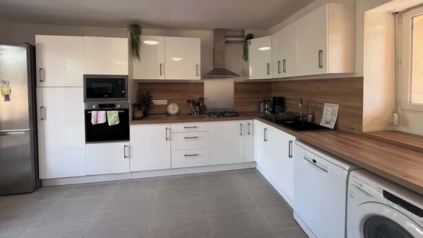A modern kitchen with white cabinets, a stainless steel refrigerator, a built-in oven, a microwave, a sink, a stove, and a dishwasher. - Villa du Cedre | House & Garden, Montrabe (Montrabé)