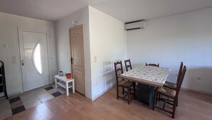 A room with a dining table, chairs, a door, and an air conditioning unit. - Villa du Cedre | House & Garden, Montrabe (Montrabé)