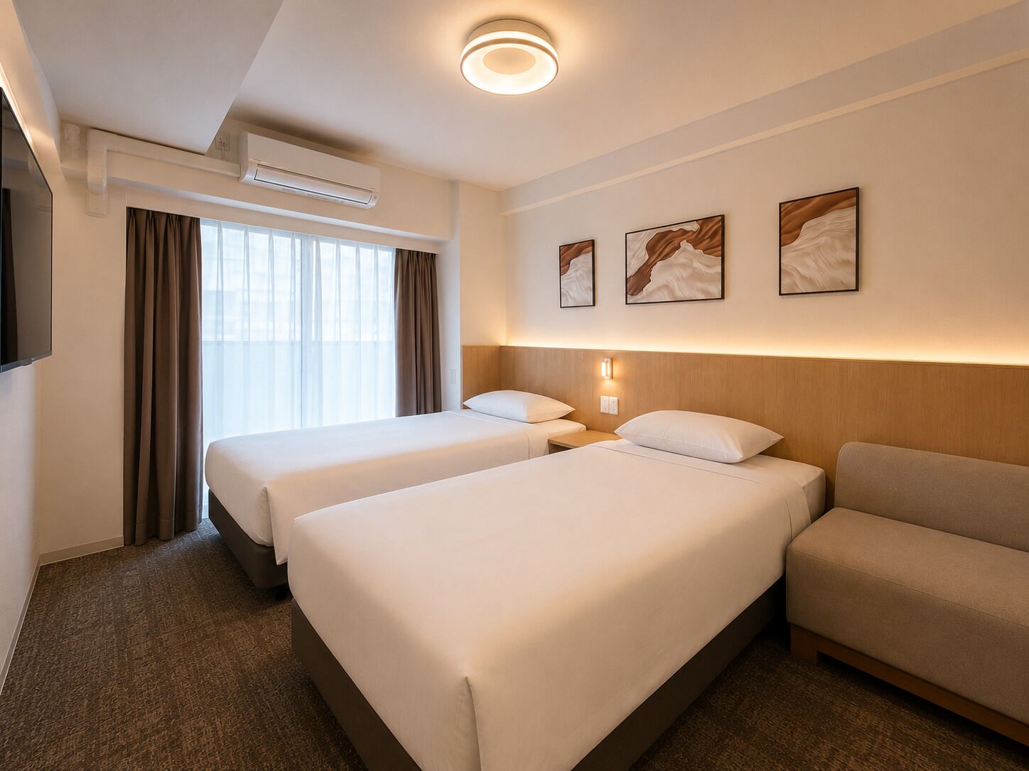 Habitación de hotel con dos camas, un sofá, un televisor de pantalla plana y una ventana con cortinas.