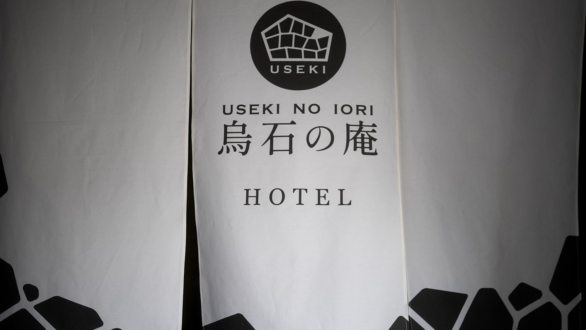 A sign for USEKI NO IORI HOTEL with Japanese text and a logo.