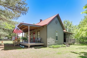 Einbungalow mit Veranda, einer kleinen Terrasse und einer Flagge.