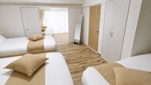 Habitación de hotel con dos camas, un armario y un espejo.