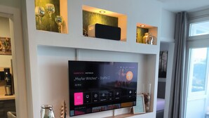 Una sala de estar moderna con televisor de pantalla plana, chimenea y una mesa de centro.