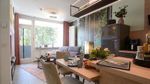 Una cocina moderna con comedor, un sofá y un amplio ventanal con cortinas.