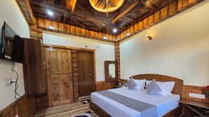 Un dormitorio con paneles de madera, una cama, un televisor y un armario de madera.