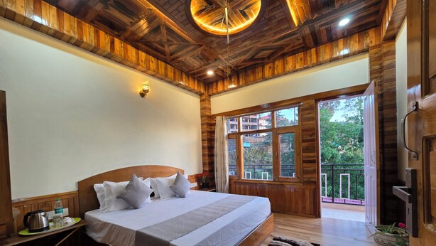 Un dormitorio con paneles de madera, una cama, una mesita de noche y vistas al exterior.