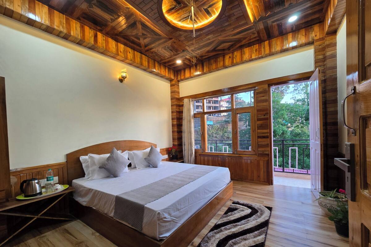A wooden-paneled bedroom with a bed, bedside table, and a view of the outdoors.
