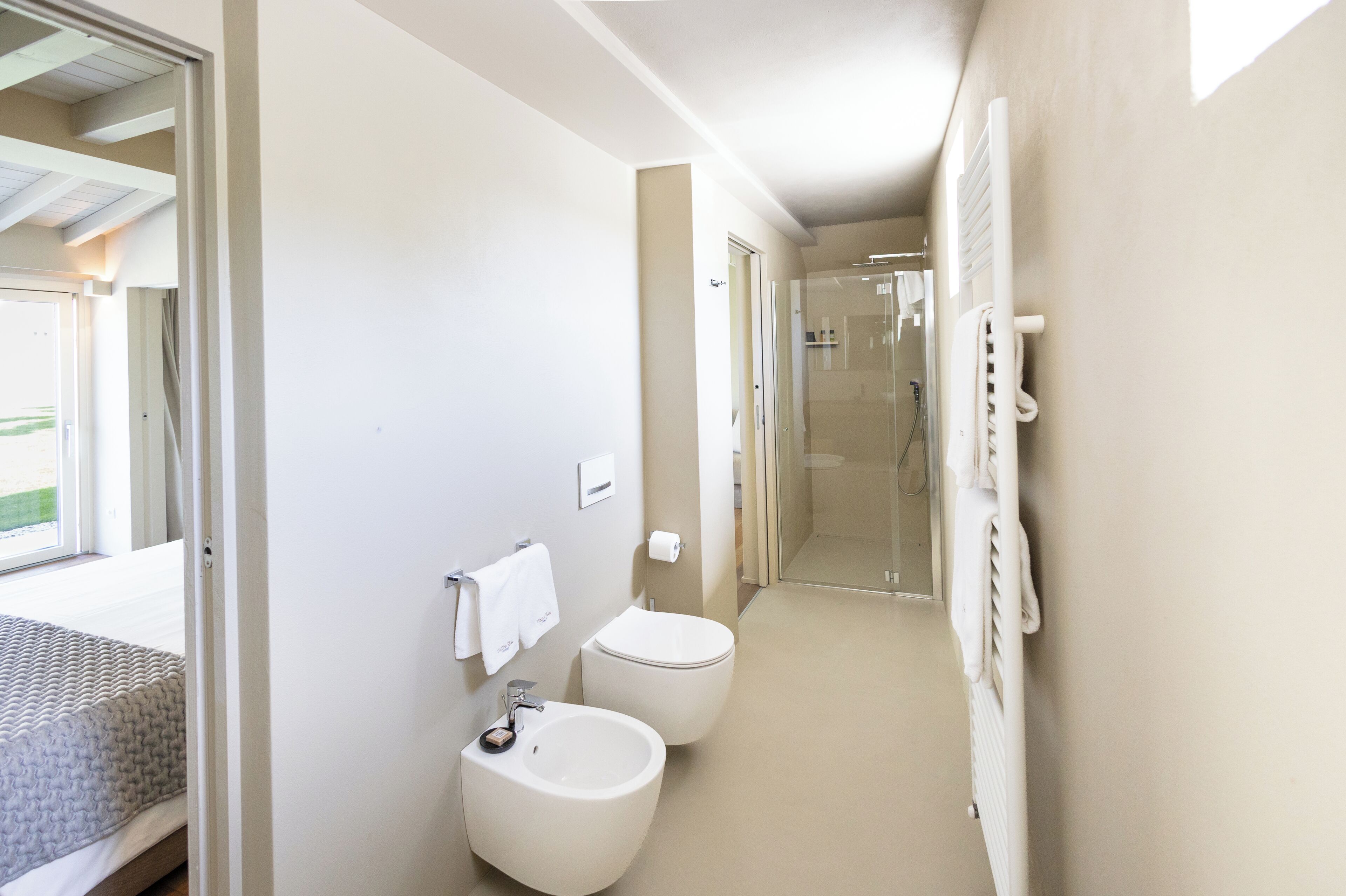 A modern bathroom with a bidet, toilet, and a shower area.