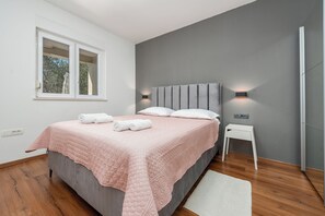 A bedroom with a bed, bedside tables, a window, and a wall-mounted light fixture. - Pool House Olive (Zemunik Donji)