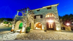 A stone building with arched doorways and a pergola structure. - Villa Poseidon - Master Suite In Zante w/Pool (Skinaria)