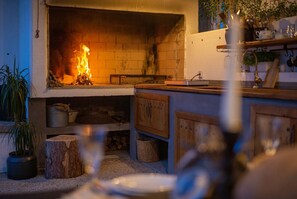 Eine gemütliche Küche mit Kamin, Holzschränken und einer Speisekammer.