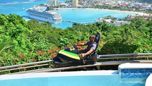 A person on a chairlift with a view of a cruise ship, a beach, and a cityscape. - Hospitality Expert SWE202 - Pool, Beach, Chef (Montego Bay)