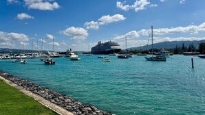 A marina with various boats, including a large cruise ship, and a rocky shoreline. - Hospitality Expert SWE202 - Pool, Beach, Chef (Montego Bay)