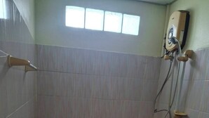 A small bathroom with a shower, a toilet, and a window. - Delight Mansion (Bangkok)