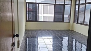 A room with a tiled floor, a door with a number sign, and large windows. - Delight Mansion (Bangkok)