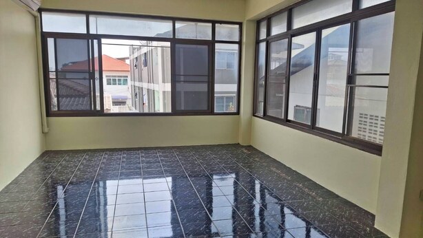 A room with large windows, a tiled floor, and a visible exterior view of buildings. - Delight Mansion (Bangkok)
