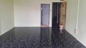 A hallway with black marble flooring, a door with a sign, and a wooden door on the right. - Delight Mansion (Bangkok)