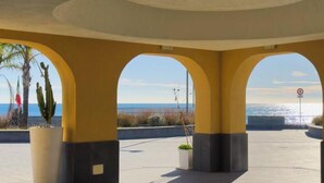 A covered outdoor area with arches, potted plants, and a view of the sea. - [Authentic Caruggio] Typical Ligurian Experience (Loano)